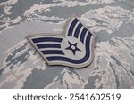 US AIR FORCE Staff Sergeant rank patch on digital tiger-stripe pattern Airman Battle Uniform background