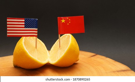 US American And Chinese Flags In A Sliced Lemon On A Chopping Block Representing The Strained Relationship And Trade War Being Waged Between The Two Countries. Foreign Policy International Relations