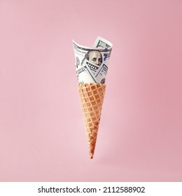 US American Dollar Bills In Ice Cream Cone On Pink Background. Business, Finance, Economy, Health Care Diabetes Expenditure Or Consumerism Concepts.