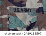 US ARMY branch tape on woodland camouflage uniform background