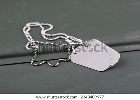 US army dog tags on green ammo can background