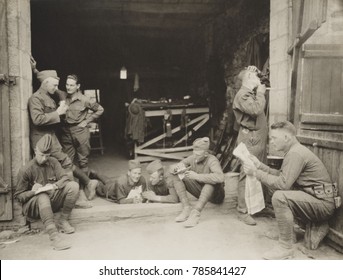 US Army Military Police off duty in France, Aug, 31, 1918. The men are talking, writing letters, cuddling a kitten, polishing a gun, shaving, and reading a magazine