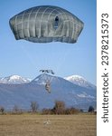 A U.S. Army paratrooper assigned to the 173rd Airborne Brigade prepares to land by pulling the risers on their T-11 parachute during a proficiency jump over Juliet Drop Zone near Pordenone, Italy 