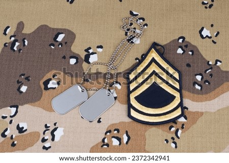 US ARMY Sergeant First Class rank patch and dog tags on Desert Battle Dress Uniform