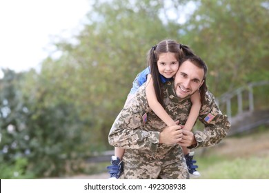 US army soldier with little daughter in park - Powered by Shutterstock