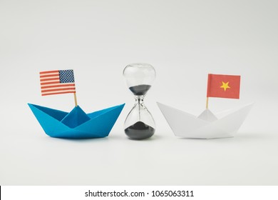 US and China financial trade war tariff strategy concept, hourglass / sandglass at the center between blue paper ship with America flag and white one with China flag.