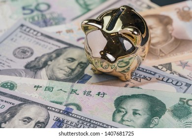 US And China Trade War And Tariff Negotiation Concept, Golden Piggy Bank On United States America And Chinese Banknotes.