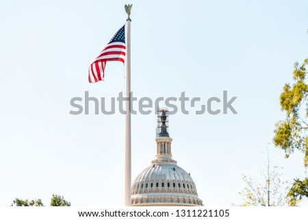 US Congress dome closeup with background of sky in Washington DC, USA on Capital capitol hill construction workers painting exterior and flag
