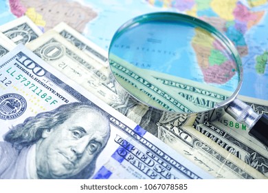 US Dollar Banknotes Money And Magnifying Glass With On Map World Background