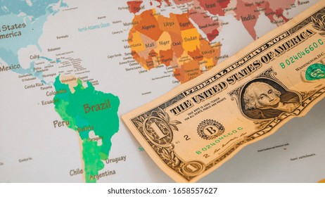 US Dollar Banknotes On Globe World Map, American Investment And Trading, Concept Of American Policy And Influence