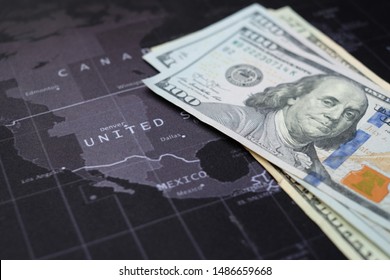 US Dollar Banknotes On World  Map, Black Gray Background With White Letter. Closed-up Banknotes And United. Economic Of USA Concept. Stock Market Of USA. Economy USA. Business Crisis. Stimulus Check 