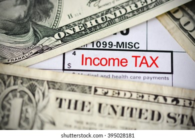 US dollar bills on tax form suggesting tax payment or audit - Shutterstock ID 395028181