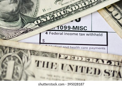 US dollar bills on tax form suggesting tax payment or audit - Shutterstock ID 395028187