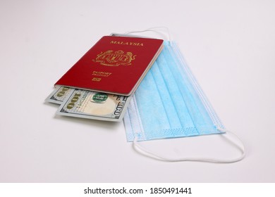 US Dollar Currency Paper Money 100 Hundred Dollar Bill Red Malaysian Passport Book Face Mask On White Background