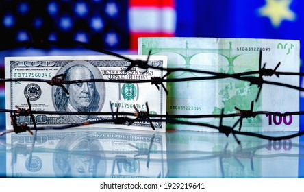 US Dollar And EU Currency Wrapped In Barbed Wire Against United States And European Union Flags As Symbol Of Joint Economic Warfare, Sanctions And Embargo Busting. Close Up.