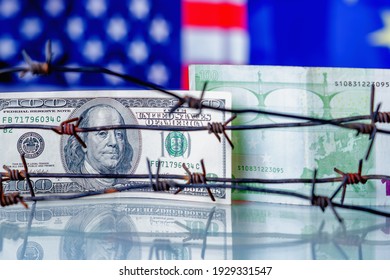 US Dollar And EU Currency Wrapped In Barbed Wire Against United States And European Union Flags As Symbol Of Joint Economic Warfare, Sanctions And Embargo Busting. Selective Focus On Dollar Banknote