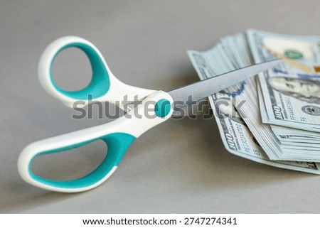 US dollar money. Decrease in the value of the dollar, Increase or decrease in interest rates. Financial and business concept. Cost analysis. Scissors cut banknotes. Close up
