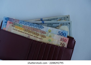 US dollar and Saudi Arabia Riyals (SAR) banknote inside wallet or purse. Concept for saving, economy, finance, business, and investment.  - Shutterstock ID 2208292795