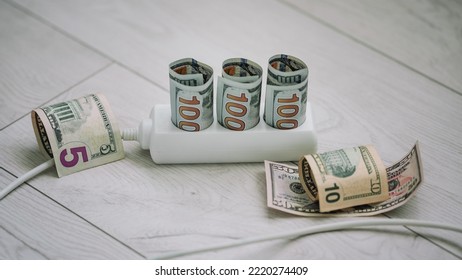 Us Dollars Banknotes Into Electrical Outlet And Next To Cord. Home Financial Budget Concept.