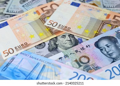 US Dollars, Chinese Yuan, Euro Banknotes And Russian Rubles. Concept Of Trade War Between The China And USA, American And European Sanctions Against Russia