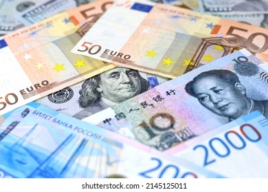 US Dollars, Chinese Yuan, Euro Banknotes And Russian Rubles. Concept Of Trade War Between The China And USA, American And European Sanctions Against Russia	