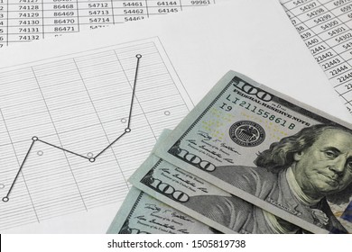 US dollars money lie on a table with a graph, and numbers. The concept of money saving and accumulating money and capital. Blur background and open space.