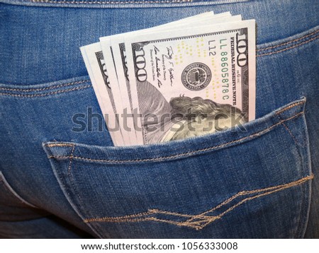 US dollars in woman's jeans pocket. Girl with dollars in the back pocket