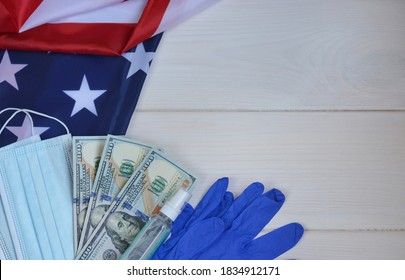 U.S. Economic Crisis Amid Coronavirus Pandemic. US Presidential Election In The Context Of The Coronavirus Pandemic.Medical Mask,gloves, Dollars, Antiseptic On The American Flag.Copy Space For Text