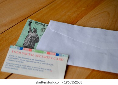 The US Federal Stimulus Check Showing The Statue Of Liberty With Envelop Next To Social Security Card On Table. People With SSN Can Receive The Covid 19 Pandemic Payment. Relief Program Concept. 