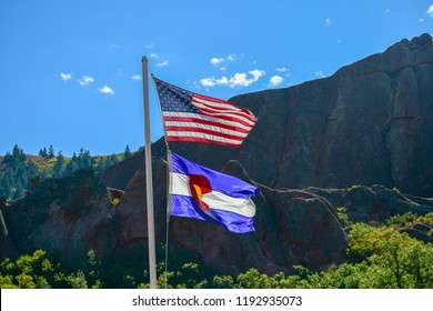 The US Flag And Colorado State Flag Proudly Wave In The Breeze In The Mountains Of Colorado USA