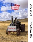 The US flag on an old steam engine, in a wheat field at the Colfax Threshing Bee in Colfax, Washington.