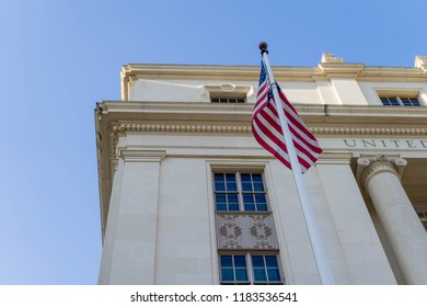 US Flag On Poll Outside Of US Postal Office Building Low Angle View