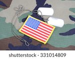 US flag patch with dog tags on woodland camouflage uniform