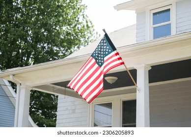 US flag proudly displayed in front of an American house symbolizes patriotism, national identity, and love for one's country. It represents unity, freedom, and the values upon which the United States  - Powered by Shutterstock