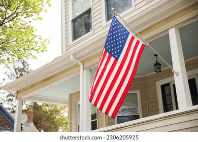 US flag proudly displayed in front of an American house symbolizes patriotism, national identity, and love for one's country. It represents unity, freedom, and the values upon which the United States 