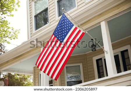US flag proudly displayed in front of an American house symbolizes patriotism, national identity, and love for one's country. It represents unity, freedom, and the values upon which the United States 