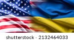 US flag together with Ukrainian flag in a single picture, flags blending one into the other.