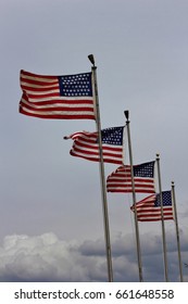 US Flags flying in the Wind four in a row.