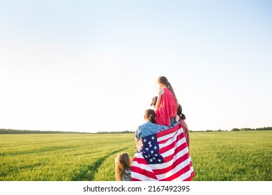US Independence Day or Memorial Day. patriotic background with copy space. family with American flag in field in nature outdoor back