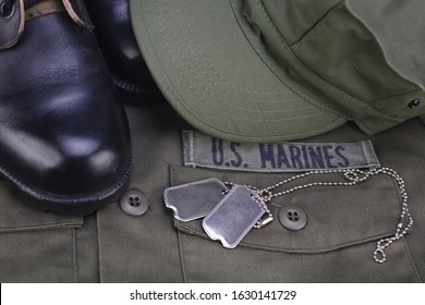 U.S. MARINES Branch Tape with dog tags and boots on olive green uniform background - Shutterstock ID 1630141729