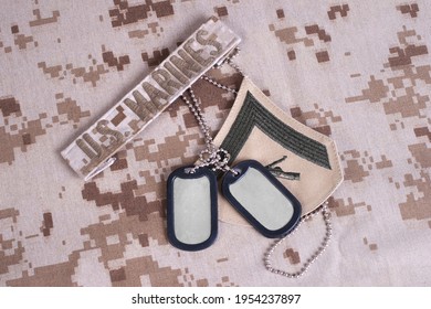 US MARINES Branch Tape With Dog Tags On Desert Camouflage Uniform Background