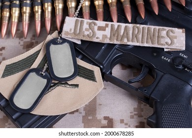 US MARINES Branch Tape With Dog Tags, Ammunition Belt And Rifle On Desert Camouflage Uniform Background