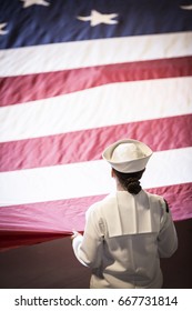 U.S. Navy Military Service Member Holds A Large American Flag During The Memorial Day Observance Ceremony On The Intrepid Sea, Air & Space Museum, Fleet Week, NEW YORK MAY 29 2017.