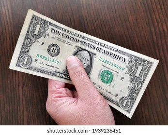 US one dollar bill in hand.
