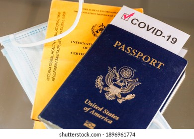 A US Passport With A Covid-19 Immunization Document, A Face Mask, And An International Certificate Of Immunization From The WHO.