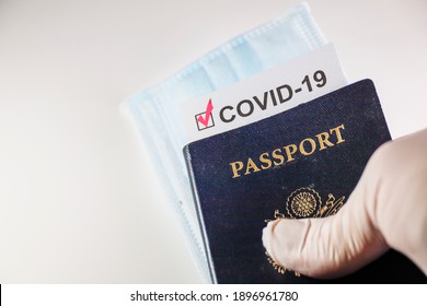 A US Passport With A Covid-19 Immunization Document And A Face Mask.