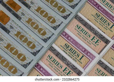 US Savings Bonds and 100 Dollar bills, representing investment choices. Savings bonds are debt securities issued by the U.S. Department of the Treasury and issued in Series EE or Series I. - Shutterstock ID 2102864275