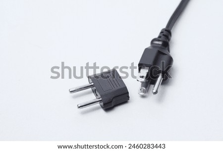 US socket with adapter to EU socket on white background