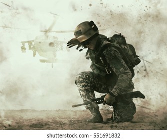 US soldier in the desert during the military operation turning to combat helicopter approaching covering his eyes. Backup is coming