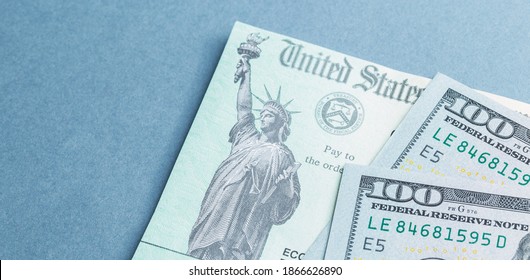  A US stimulus check with some one-hundred-dollar bills - Shutterstock ID 1866626890